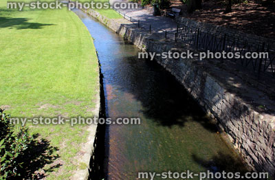 Stock image of stream with clear water, running through park lawn
