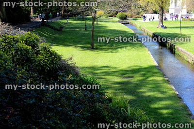 Stock image of photo of long straight stream through public park and gardens