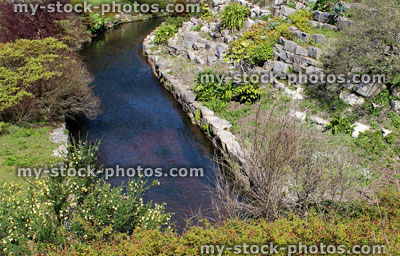 Stock image of established English rock garden (rockery) with stream