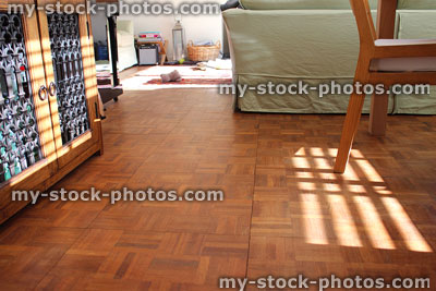 Stock image of wooden parquet floor in sitting room with green sofa