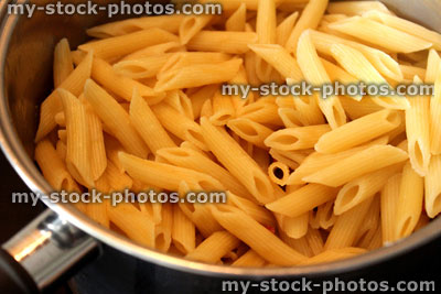 Stock image of freshly cooked penne pasta in saucepan, awaiting sauce