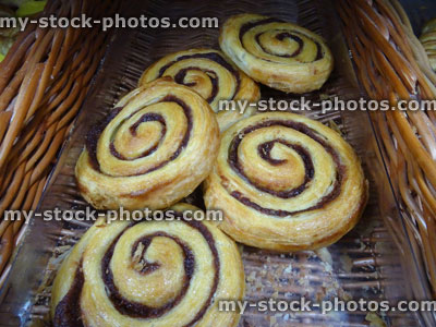 Stock image of freshly baked, Danish puff pastry swirls wicker basket