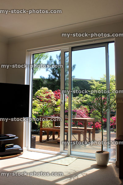Stock image of aluminium patio doors overlooking back garden with decking