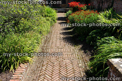 Stock image of red brick path, block paving, paved pathway, herringbone pattern / raised beds