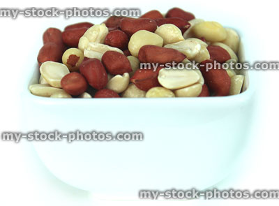 Stock image of mixed red skin peanuts in white dish, health benefits