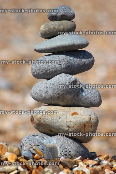 Stock image of towering stack of pebbles on beach, balancing stone tower