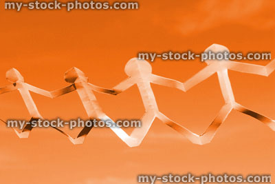 Stock image of white people paper chain of dolls, men holding hands, orange background