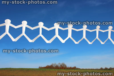 Stock image of white people paper chain of dolls, men holding hands, blue sky