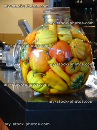 Stock image of pickled gourds, peppers and chilies in glass jar