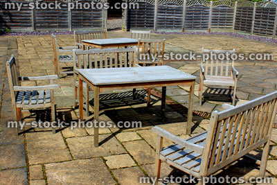 Stock image of wooden garden table, chairs and benches on patio 