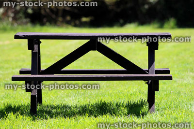 Stock image of wooden picnic table in field of mown grass