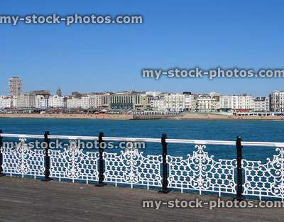 Stock image of Brighton beach, sea and hotels through pier railings