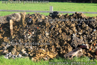 Stock image of large pile of soil / stones and building rubble in field