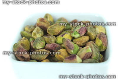 Stock image of shelled pistachio seeds / nuts in dish, healthy diet food