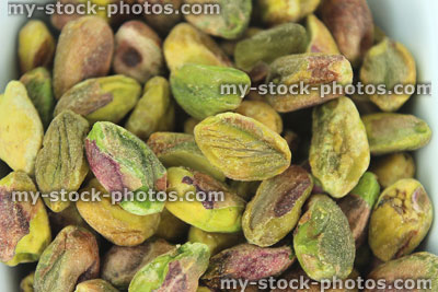 Stock image of shelled pistachio seeds / nuts close up, health benefits of kernels