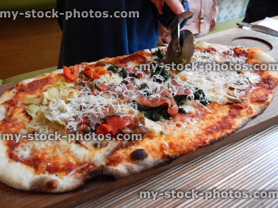Stock image of cheese and tomato margherita pizza, Italian restaurant, pizza wheel cutter / cutting