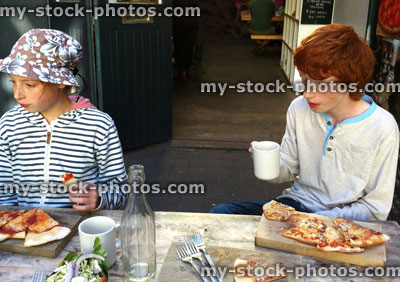 Stock image of children eating homemade pizza outside an artisan bakery