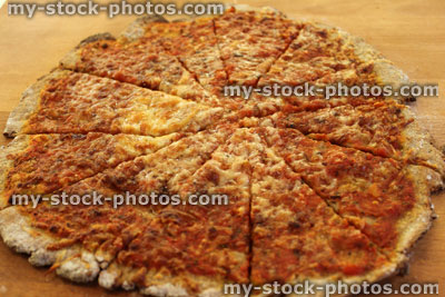 Stock image of homemade margherita pizza cut into slices, wooden board