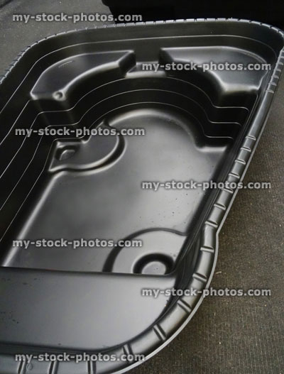 Stock image of moulded, preformed black plastic garden pond, high density polyethylene (HDPE) / fibreglass