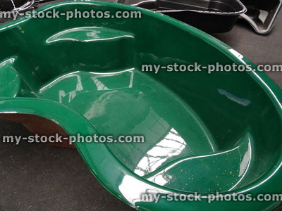 Stock image of moulded, preformed green plastic garden pond, high density polyethylene (HDPE) / fibreglass