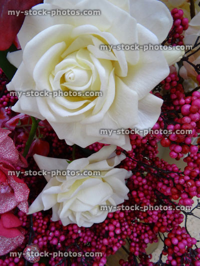 Stock image of artificial plastic / silk rose flowers, fake white roses, pink berries