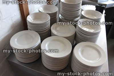 Stock image of piles / stacks of white plates, commercial kitchen / buffet