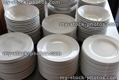 Stock image of piles / stacks of white plates, commercial kitchen / buffet