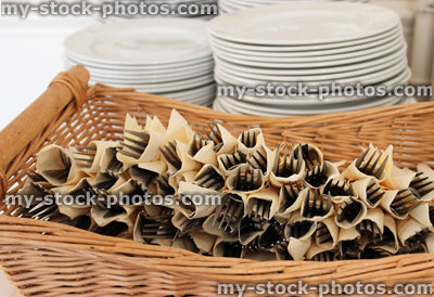 Stock image of stacks of white plates at buffet, cutlery (knifes / forks / napkins)
