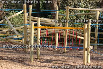 Stock image of children's playground in woodland park, wooden climbing frames / equipment