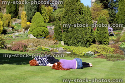 Stock image of boy / girl relaxing on garden lawn in sun