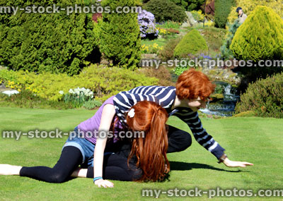 Stock image of boy and girl playing and wrestling in garden