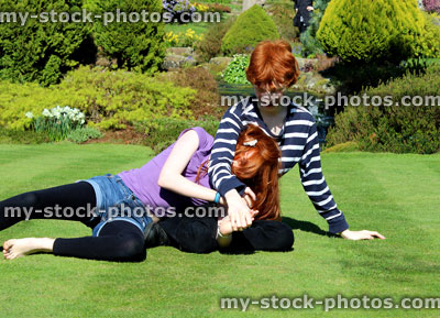 Stock image of children in garden enjoying fun playful wrestling