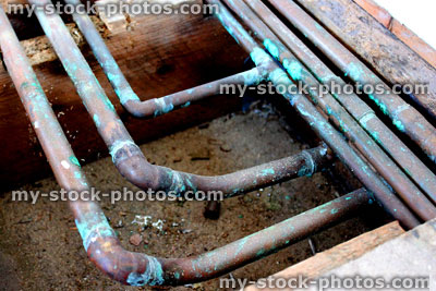 Stock image of old copper underfloor central heating pipes, plumbing (close up)
