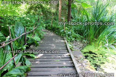Stock image of bridge over stream with wooden decking, chicken wire, slippery surface