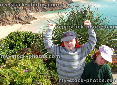 Stock image of young brother / sister on cliff overlooking Porthcurno beach