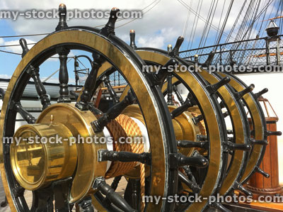 Stock image of shiny ship brass wheel and nautical rope
