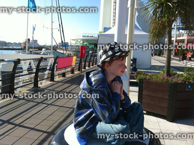Stock image of boy sat on Gunwharf Quays, Portsmouth, Hampshire