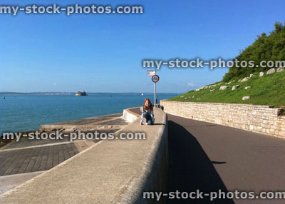 Stock image of young girl on seafront wall, by Portsmouth beach