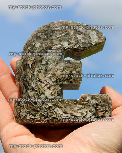 Stock image of Great British Pound (GBP) currency symbol ornament, held in hand
