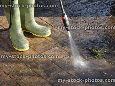 Stock image of boy with powerwasher / pressure washing hose, washing block paved drive