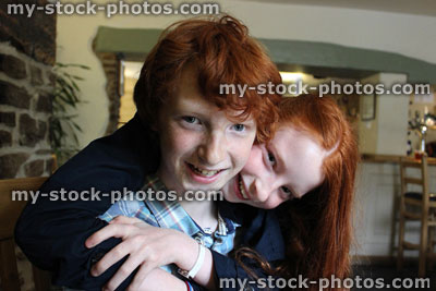 Stock image of happy brother and sister smiling, laughing, messing about and playing