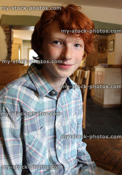 Stock image of teenage boy with red hair, smiling, looking happy