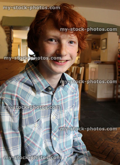 Stock image of teenage boy with red hair, smiling, looking happy