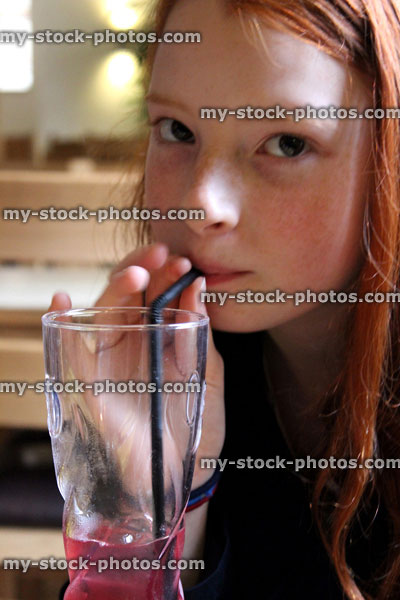 Stock image of pretty young child drinking and sucking on straw