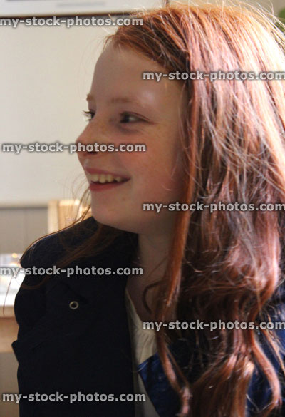 Stock image of young girl with long red hair, thinking, day dreaming