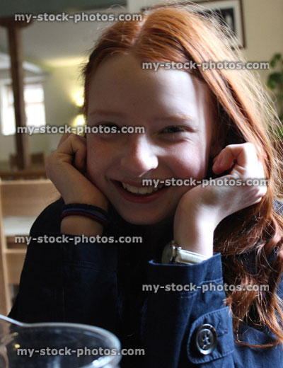 Stock image of young girl with long red hair, giggling, smiling and posing