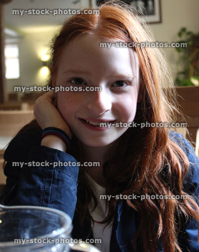 Stock image of young girl with long red hair, laughing, smiling and posing