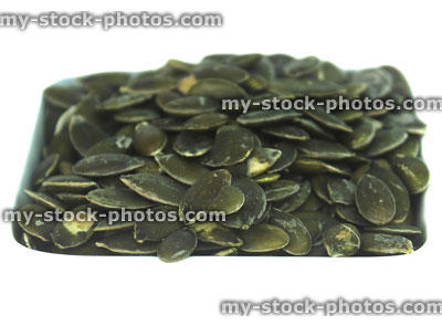 Stock image of pumpkin seed pile, high protein healthy eating food, health benefits
