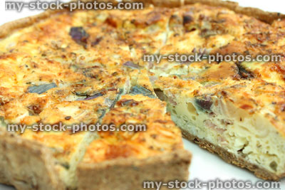 Stock image of sliced homemade bacon and egg quiche tart / savoury flan