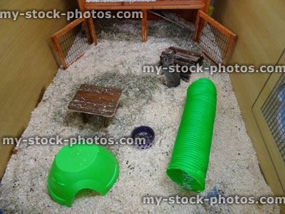 Stock image of indoor rabbit run cage / pen, tunnels, wooden house, woodshavings / sawdust